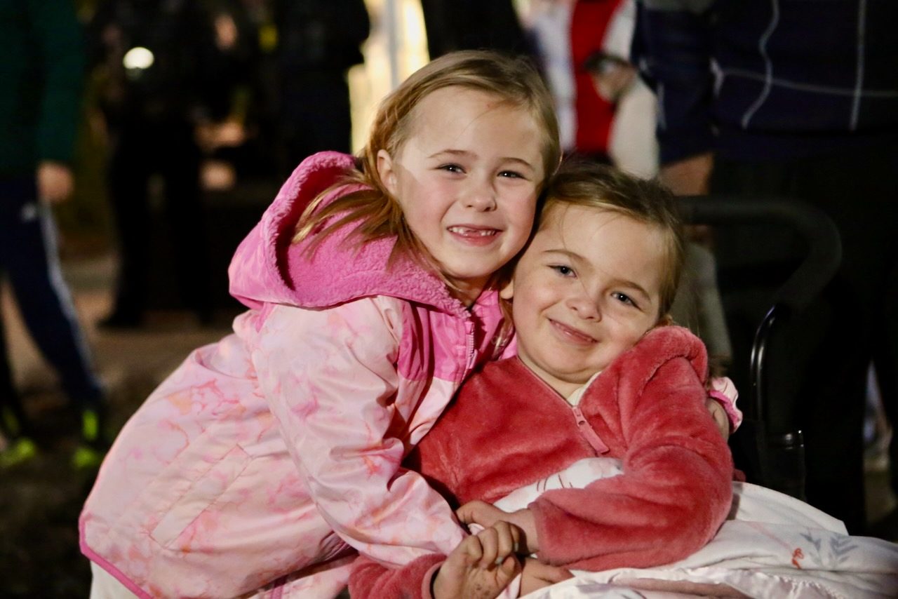 Two girls hugging and laughing at VIP Christmas