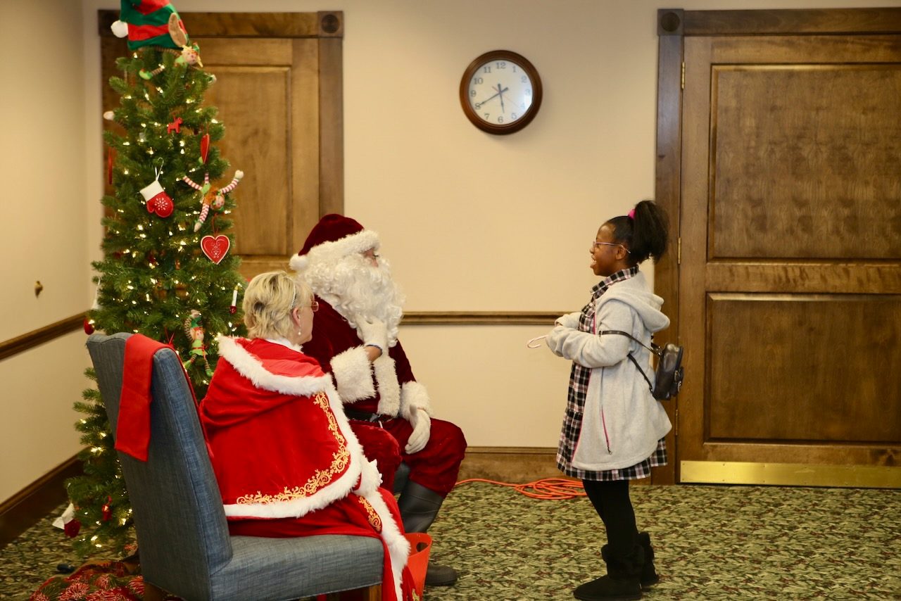 A child meeting Santa and Mrs. Claus at VIP Christmas